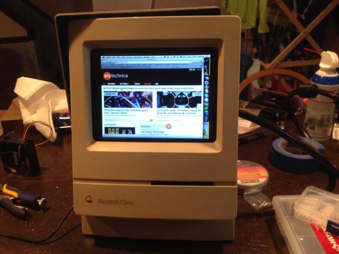 A Macintosh Classic... but with a color LCD replacing the monitor showing the website Ars Technica.