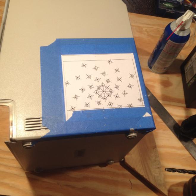 The Mac case with a paper template taped on the side showing where vent holes would be drilled.