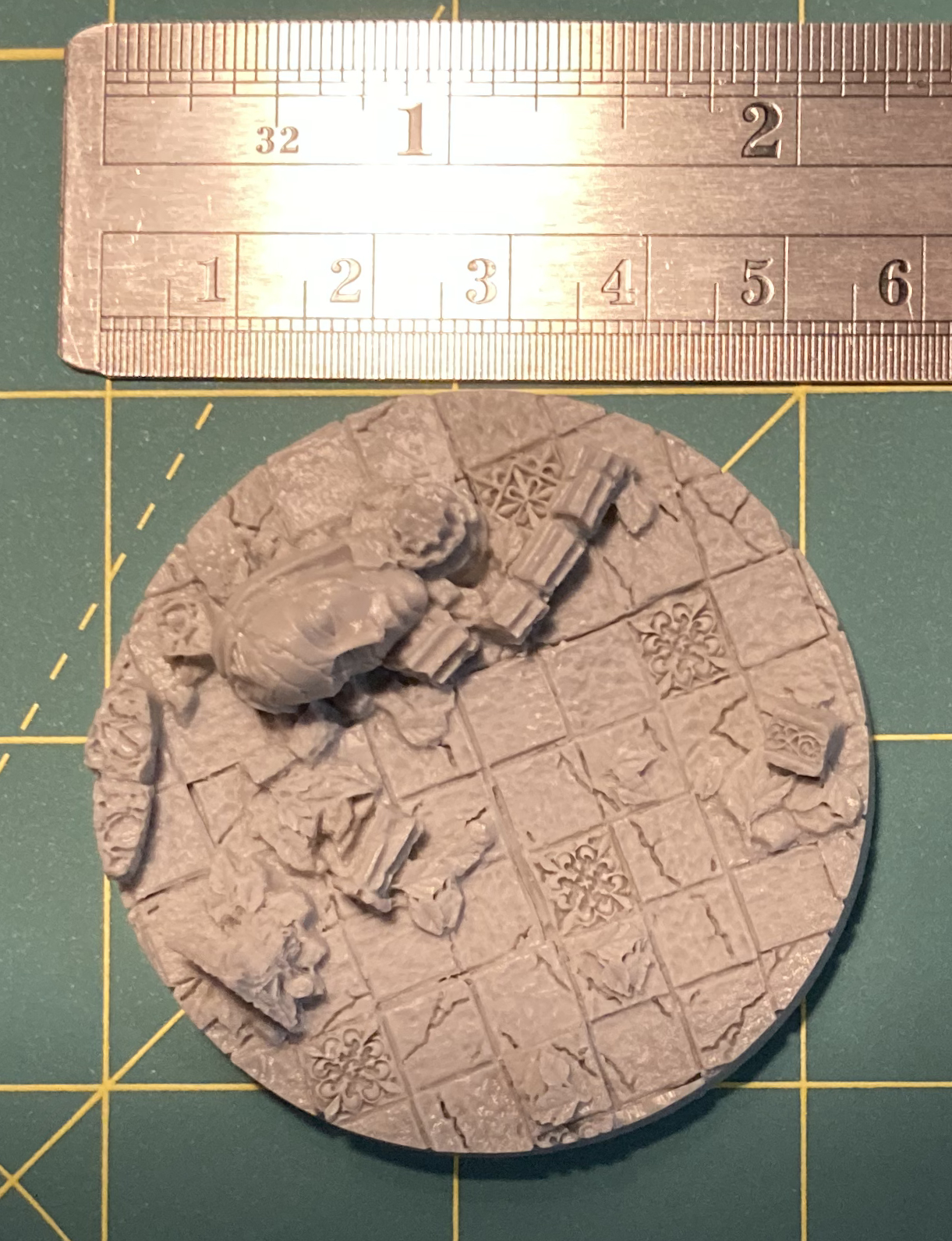 Base showing large stone tiles covered with debris and vegetation. Simialr to the previous, but ruler shows the diameter is a bit smaller.