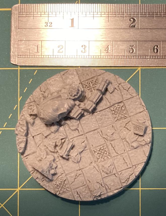 Base showing large stone tiles covered with debris and vegetation. Simialr to the previous, but ruler shows the diameter is a bit smaller.