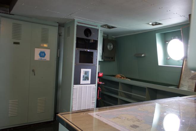 Room on ship containing cabinets and racks.